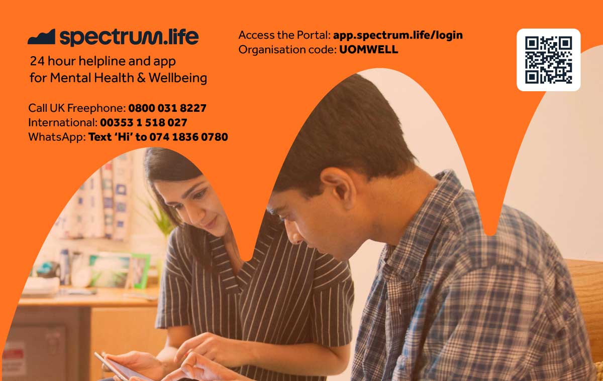 An image of 2 students sat in the bedroom of the University of Manchester accommodation looking at the Spectrum Life portal on a tablet.